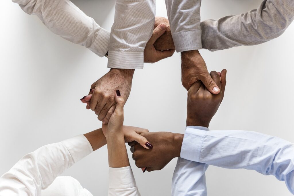 four people with hands connected together between them